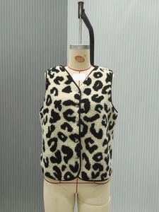 Detail of leopard print fleece vest showing soft texture and contrast v-neck trim