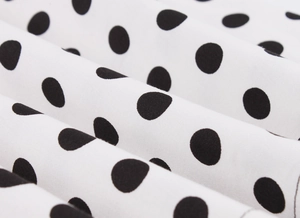 Macro detail of white polka dot fabric texture with soft drapes and vintage patterns