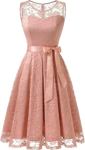 Détail d'une robe en dentelle rose poudré sans manches avec motifs floraux et nœud en satin