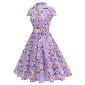 Macro detail of lavender retro dress featuring orange rose prints and a waist tie bow