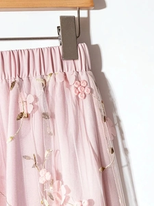 Detailed view of pink mesh skirt with 3D floral embroidery and elastic waistband