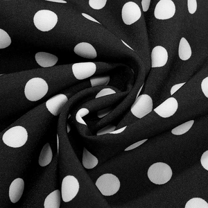 Close-up of black and white polka dot fabric texture with elegant draped pattern details