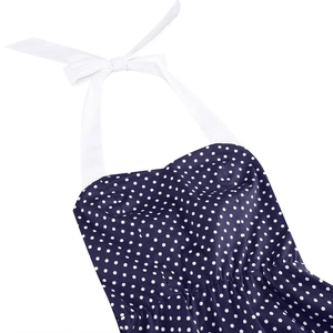 Detail of navy blue polka dot dress featuring a white halter neck tie and sweetheart neckline