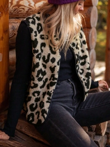 Close-up of leopard print faux fur vest with button closure on outdoor wooden background