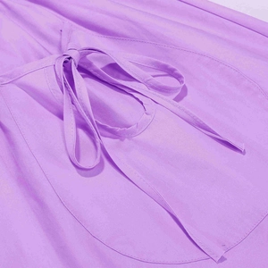Détail de robe en coton violet avec nœud à la taille et poche ronde plaquée élégante