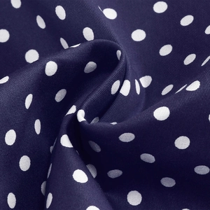 Detailed close-up of dark blue polka dot fabric showing texture and soft drape