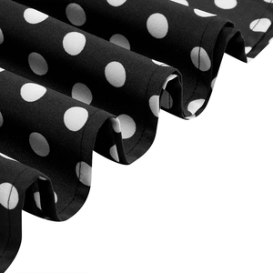 Macro view of black and white polka dot pattern fabric with elegant pleated hem details