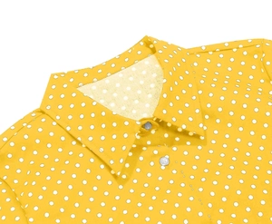Detailed close-up of yellow polka dot polo shirt with classic collar and white buttons