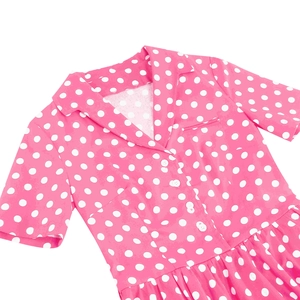 Dettaglio dell'abito vintage a pois rosa con revers classico e bottoni bianchi