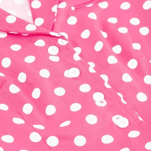 Dettaglio della camicetta rosa a pois con colletto a revers e bottoni bianchi