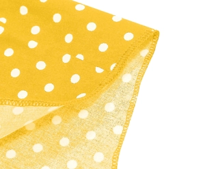 Close-up of yellow polka dot fabric showing detailed stitching and edge seam finish
