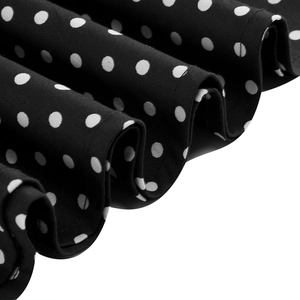 Detailed view of black polka dot fabric showing fine stitching and draped texture