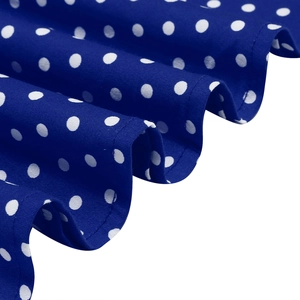 Detailed view of dark blue fabric with white polka dots and delicate pleated edge