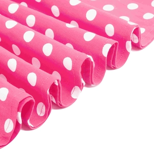 Dettaglio ravvicinato del tessuto rosa a pois con morbide pieghe e trama di cotone