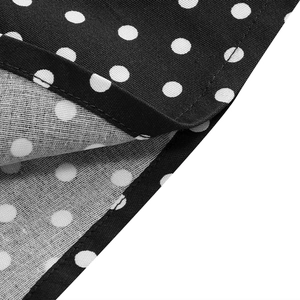 Close-up of black fabric with white polka dots showing stitching detail and texture