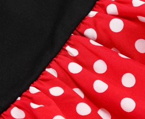 Detail of waist seam with pleats on a red polka dot dress with black upper part