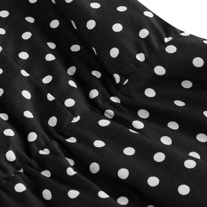 Close-up of black and white polka dot fabric texture with fine stitching details