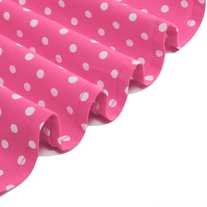 Detailed close-up of pink polka dot dress showing fine stitching and fabric texture