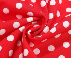 Close-up of red and white polka dot dress fabric showing soft texture and drape detail