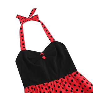 Detailed view of polka dot halter dress with red bow tie and black button accents