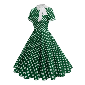 Detailed view of dark green Audrey Hepburn style polka dot dress with a white bow tie