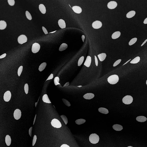 Close-up of black and white polka dot fabric texture with elegant soft folds