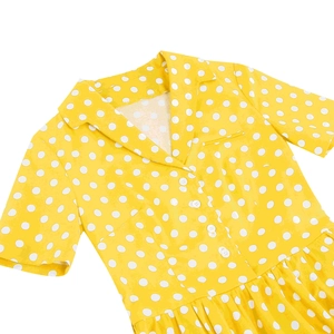 Dettaglio vestito giallo a pois con bottoni bianchi e colletto a rever classico