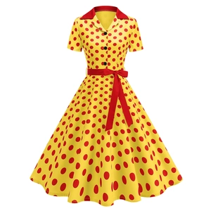 Dettaglio dell'abito vintage giallo a pois con colletto a rever rosso e fiocco in vita