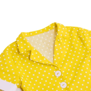 Detail of yellow polka dot dress showing white collar and resin button closure