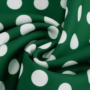 Close-up of vintage dark green fabric with white polka dots for retro Hepburn style dress