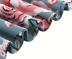 Detail of vintage floral fabric showing pink roses and twill weave on blue background