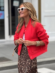Dettaglio giacca bomber rosso vivace con bottoni dorati e ampie tasche quadrate applicate