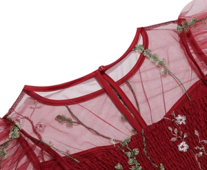 Detail of burgundy mesh dress with floral embroidery and smocked chest bodice