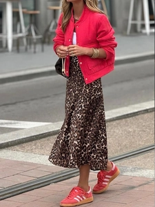 Scatto street style di una giacca rossa accesa con una gonna midi a stampa leopardata