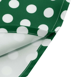 Detail shot of white polka dots on dark green fabric with high-quality stitching