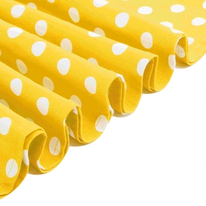 Dettaglio del tessuto giallo a pois bianchi con morbida trama a pieghe naturali