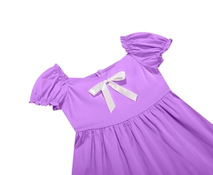 Dettaglio di un abito viola per bambina con fiocco in raso bianco e scollatura quadrata