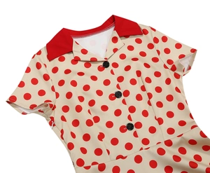 Dettaglio dell'abito rétro a pois con colletto rosso e cerniera laterale invisibile