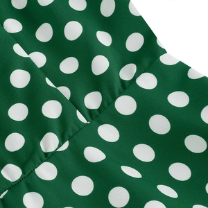 Detail shot of the vintage green dress featuring white polka dots and high-quality stitching