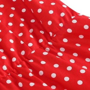 Macro view of red polka dot fabric texture with white dots on a vintage flared dress