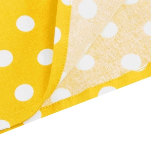 Dettaglio del tessuto giallo a pois con cuciture a doppio ago e trama del materiale fine