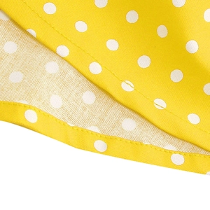 Detailed macro view of yellow polka dot fabric with precise stitching on girl dress
