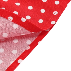 Detail of red polka dot dress fabric showing high-quality stitching and cotton texture