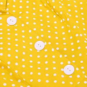 Detail des gelben Polka-Dot-Kleiderstoffs mit drei weißen Rundknöpfen und sauberer Naht