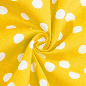 Dettaglio macro del tessuto giallo a pois bianchi con trama morbida e piega a spirale