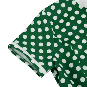 Detail shot of the white polka dot pattern on a green dress with a cuffed sleeve hem