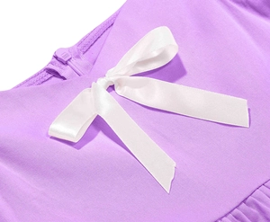 Dettaglio dell'abito viola da bambina con fiocco in raso bianco e cerniera posteriore invisibile