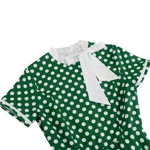 Detail of vintage polka dot dress with forest green fabric and white bow neckline