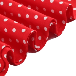 Detail of red and white polka dot dress fabric showing high-quality vintage pattern texture