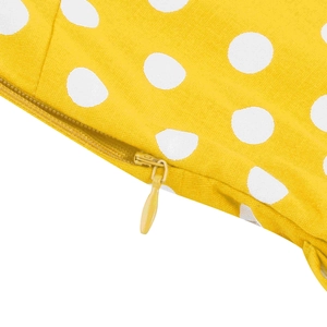 Dettaglio della cerniera invisibile su un abito giallo a pois con cuciture rifinite